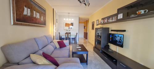 a living room with a couch and a tv and a table at Apartamento Los Balandros in Palm-mar