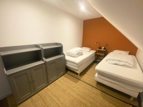 Cette chambre mansardée comprend 2 lits et un lavabo. dans l'établissement Cottage de Vittefleur, à Vittefleur