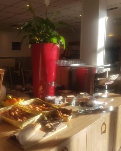 a counter with some food on top of it at KYRIAD ORANGE Centre Ville - HOTEL & RESTAURANT & BAR - La Galerie d'Art des Princes - Provence Alpes Côte d'Azur - France - Proche A7-A9 - exit21- Châteauneuf-du-Pape Avignon Bollene Nimes - 24h-24h in Orange