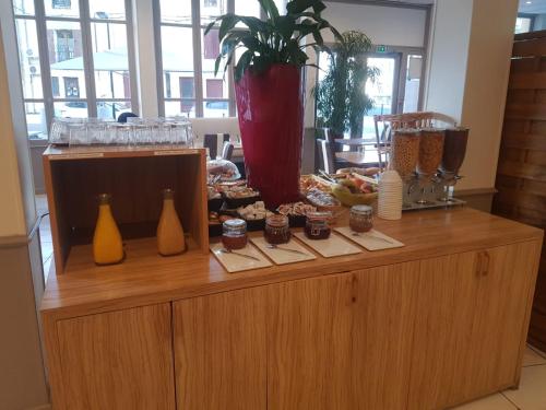 a buffet with food on top of a wooden cabinet at KYRIAD ORANGE Centre Ville - HOTEL & RESTAURANT & BAR - La Galerie d'Art des Princes - Provence Alpes Côte d'Azur - France - Proche A7-A9 - exit21- Châteauneuf-du-Pape Avignon Bollene Nimes - 24h-24h in Orange