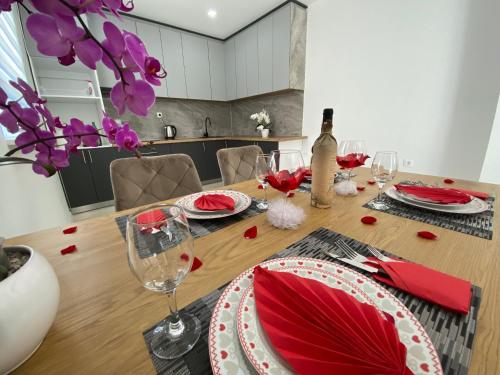 a dining room table with red napkins and wine glasses at Apartmani Pranić in Mostar