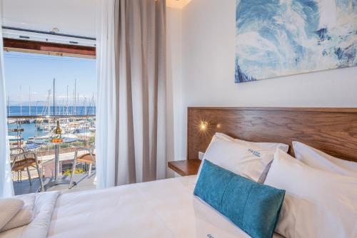 a bedroom with a bed with a view of a harbor at Galatia Studios and Apartments in Benitses