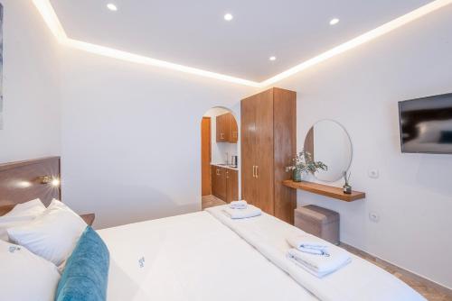 a bedroom with a bed and a tv on the wall at Galatia Studios and Apartments in Benitses