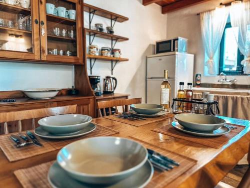 a kitchen with four bowls on a wooden table at Castaway's View Villa in Avlákia