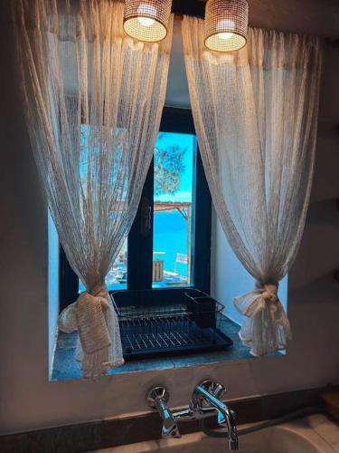 a mirror above a sink with a laptop in a window at Castaway's View Villa in Avlákia