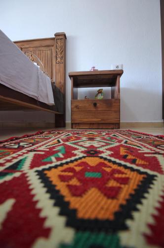a bedroom with a bed and a rug on the floor at Guri Guesthouse in Gjirokastër