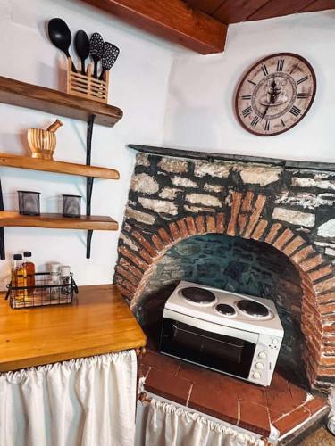 a kitchen with a brick oven with a clock on the wall at Castaway's View Villa in Avlákia