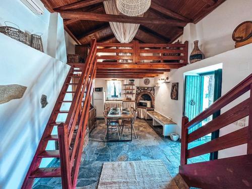 a room with a staircase and a table and a fireplace at Castaway's View Villa in Avlákia