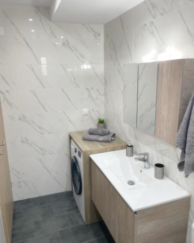 a bathroom with a sink and a washing machine at Villa Flora in Afantou