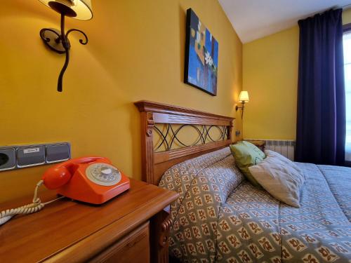 a bedroom with a bed with a telephone on a desk at Hotel Virginia R.H. in Vinuesa