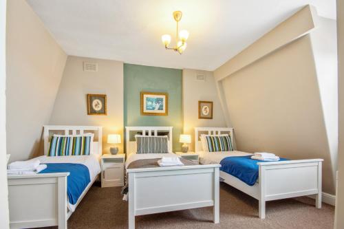 1 dormitorio con 2 camas y 2 mesas en The Kings Arms en Londres