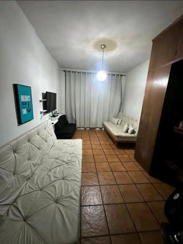 a living room with a couch and a tv at Studio em Santos Kitnet in Santos