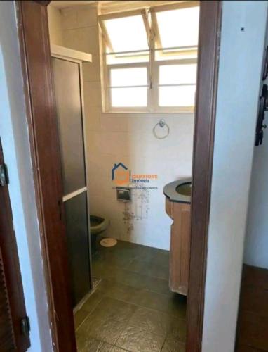 a bathroom with a sink and a toilet and a window at Studio em Santos Kitnet in Santos