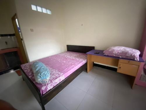 a small bedroom with a bed and a desk at OYO Life 93407 Kos Sweta in Tjakranegara