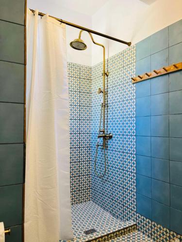 a bathroom with a shower with blue tiles at Vintage lover's getaway in Antiparos