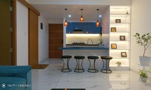 - une cuisine avec trois tabourets de bar dans le salon dans l'établissement Sreedhanya vantage point, à Trivandrum