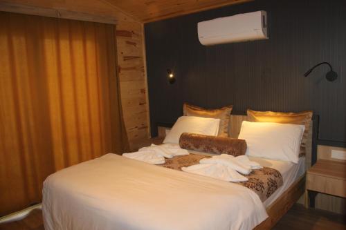 凱梅爾的住宿－Çıralı Villa's，卧室配有带毛巾的大型白色床