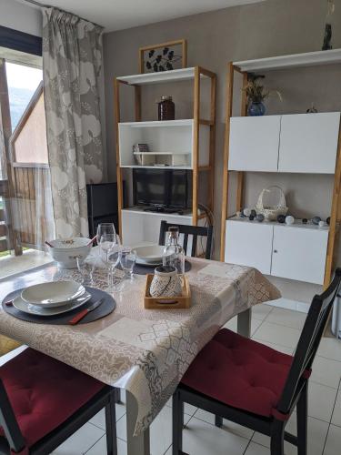 a kitchen with a table with plates and wine glasses at Les Campanules du rivage in Embrun
