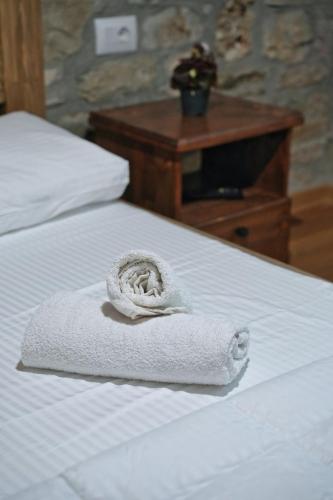 a white towel sitting on top of a bed at Guri Guesthouse in Gjirokastër