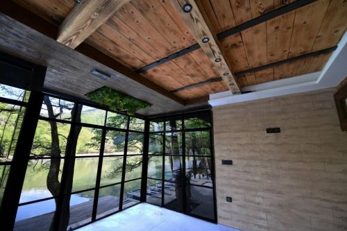 an interior view of a room with wood ceilings and windows at Villa Luxury Medjuvrsje in Međuvršje