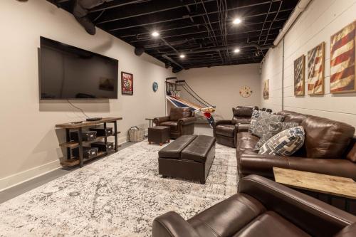 a living room with leather furniture and a flat screen tv at Hemlock Hideaway in Ellijay