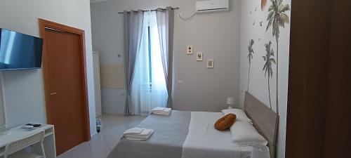 um pequeno quarto com uma cama e uma janela em F.A.M. ROOMS em Ciampino