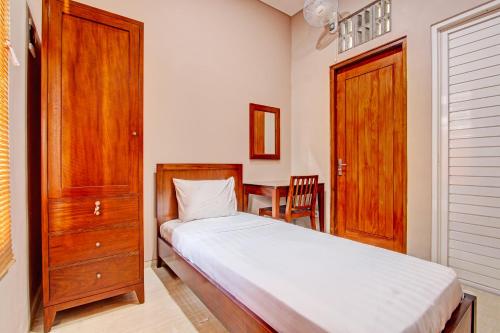 Schlafzimmer mit einem Bett und einem Holzschrank in der Unterkunft OYO Life 93497 Griya Kost Rr in Salatiga