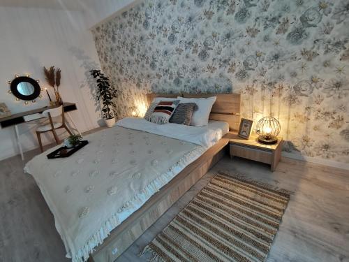 sypialnia z dużym łóżkiem i tapetą w kwiaty w obiekcie City Center Accommodation - 108 w mieście Reşiţa