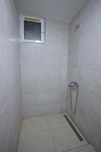 a bathroom with a shower with a window at Guri Guesthouse in Gjirokastër