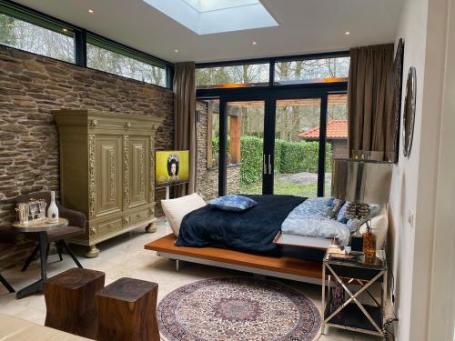 um quarto com uma cama e uma parede de pedra em Villa Royale em Oranjewoud