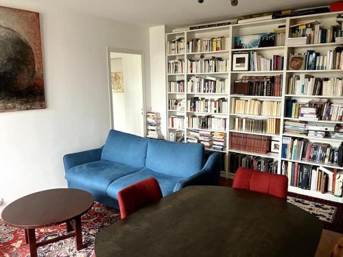 un salon avec un canapé bleu et une table dans l'établissement Charmant appartement au calme, à Villemomble
