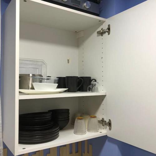 a white cabinet with plates and dishes on it at Unique Apartment La Pineda in La Pineda