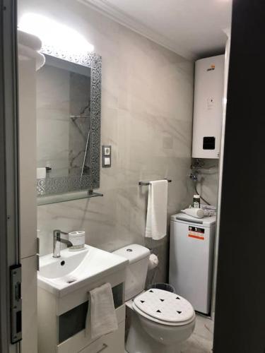 a white bathroom with a toilet and a sink at Unique Apartment La Pineda in La Pineda