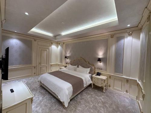 - une chambre avec un grand lit et une télévision dans l'établissement FrankFort Expo Hotel, à Tachkent