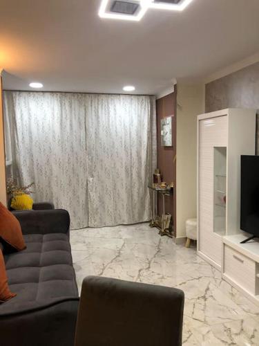 a living room with a couch and a television at Unique Apartment La Pineda in La Pineda