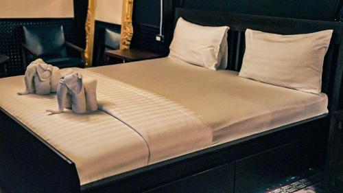 a large bed with shoes on top of it at Letana Hotel in Bang Phli