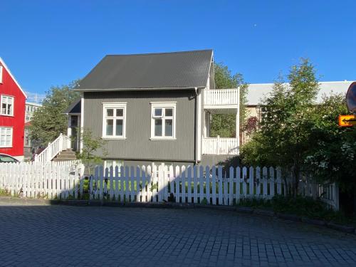 a small house with a white picket fence at Day Dream - Vesturgata 5a Luxury Apartment in Reykjavík
