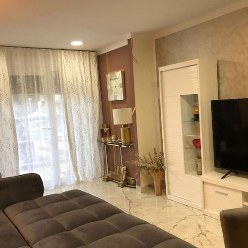 a living room with a couch and a flat screen tv at Unique Apartment La Pineda in La Pineda