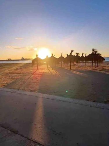 a group of people walking on the beach at sunset at Unique Apartment La Pineda in La Pineda