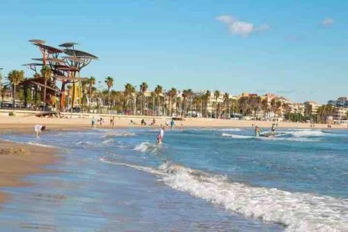 a beach with a bunch of people in the water at Unique Apartment La Pineda in La Pineda
