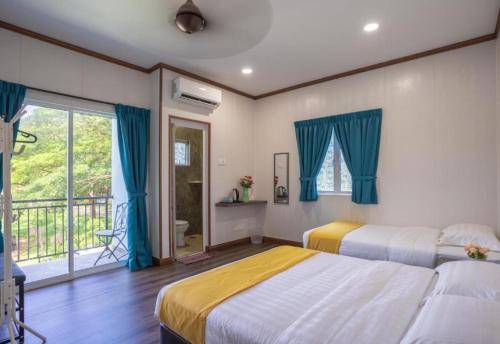 a bedroom with two beds and a balcony at Atlantis Villa Best homestay malaka in Kampong Alor Gajah