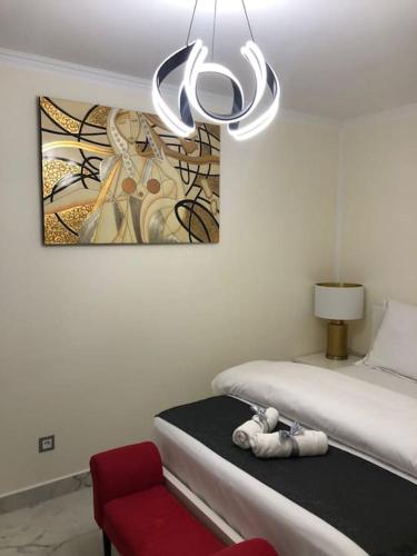 a stuffed animal sitting on a bed next to a red chair at Unique Apartment La Pineda in La Pineda