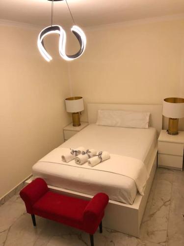 a bedroom with a white bed and a red chair at Unique Apartment La Pineda in La Pineda