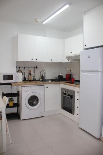 a kitchen with a washing machine and a white refrigerator at TBC The Beach Corner in Canet de Berenguer