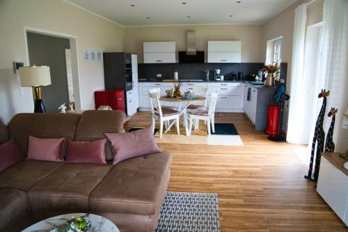 een woonkamer met een bank en een tafel en een keuken bij Landidylle in Nalbach
