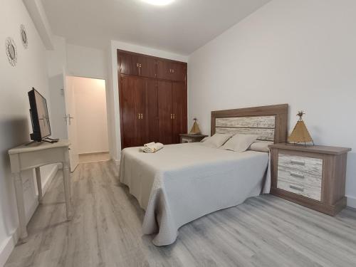 1 dormitorio con 1 cama blanca y TV en Mi Duende en Arenas de San Pedro