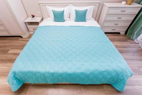 uma cama com um edredão azul num quarto em Heaven - райские апартаменты em (( Gornyy Gigant ))