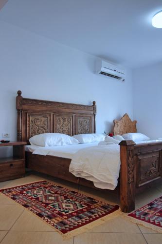 a bedroom with a large bed with a wooden frame at Guri Guesthouse in Gjirokastër