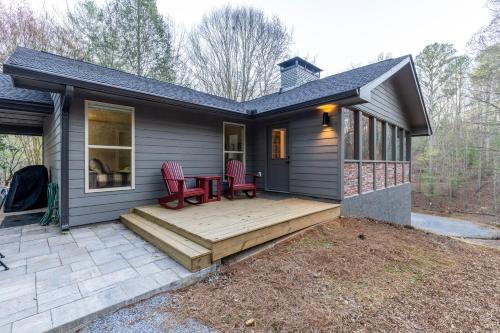 a small house with a deck and red chairs at Hemlock Hideaway in Ellijay