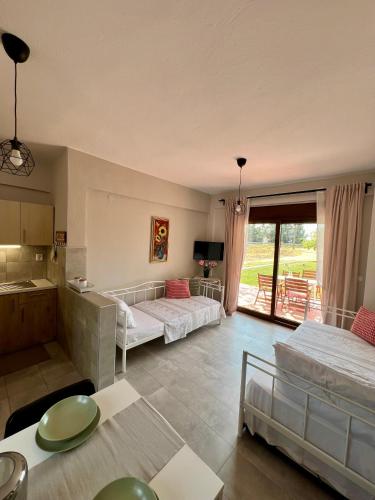 a bedroom with two beds and a kitchen with a balcony at Lucid Dream Apt. Bozinis 2 in Psakoudia